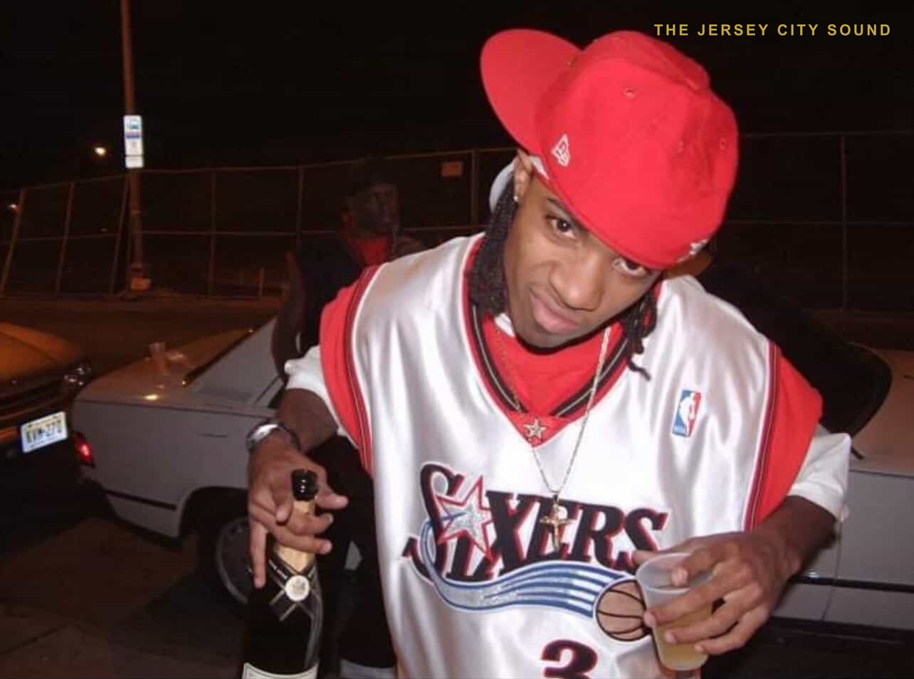 DJ E Double in a Sixers jersey at night with DJ DX behind him in a black jersey, 2001
