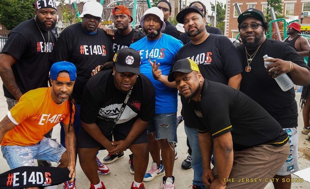 Ten members of Exit 14 DJs in matching E14DJS shirts at a park
