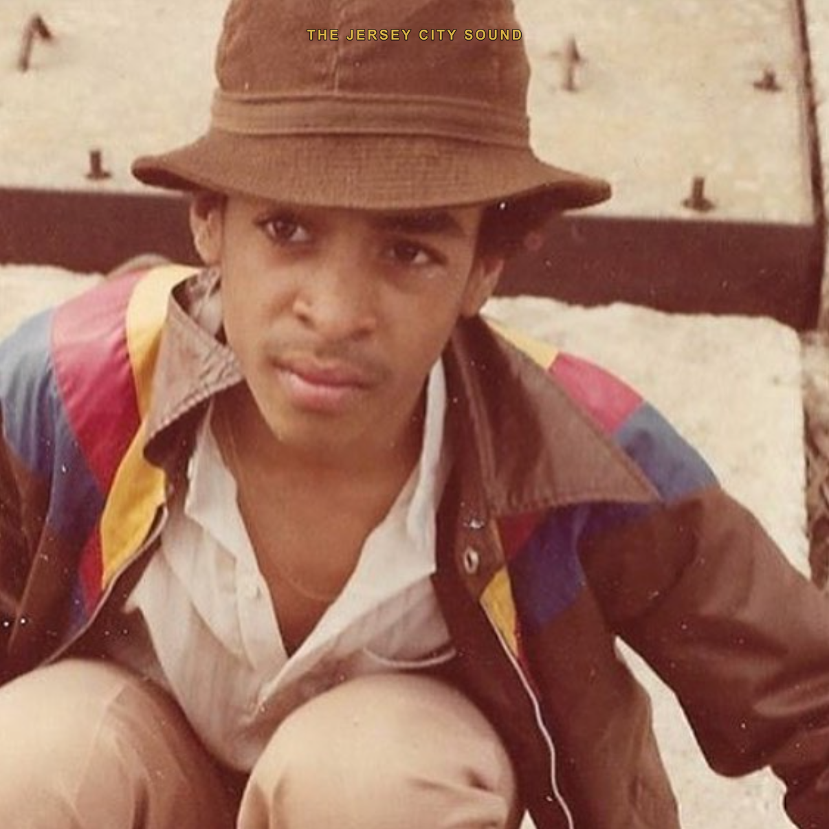 A young Lord Sun Albee Al in a brown bucket hat and color paneled jacket
