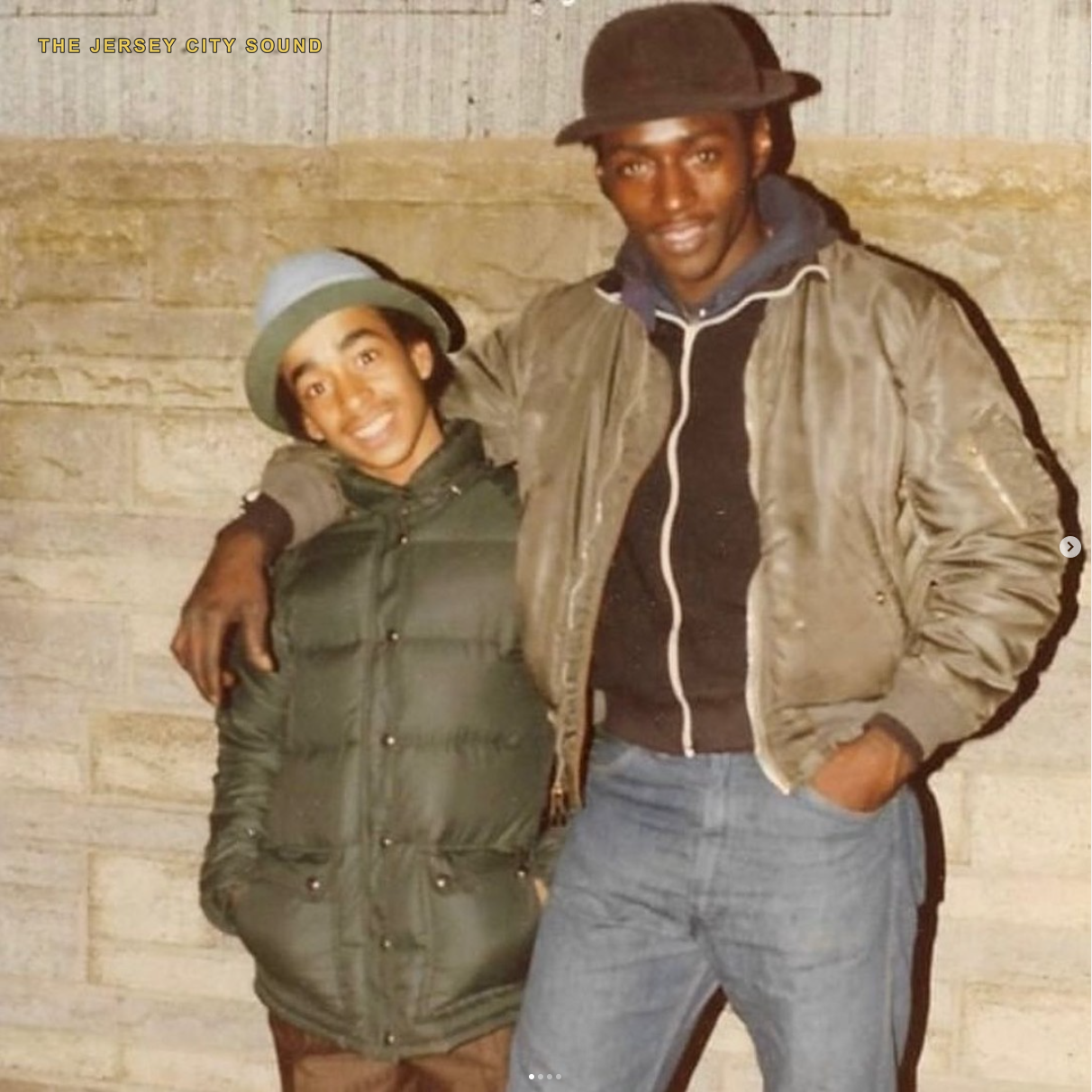 Lord Sun Albee Al in a dark hat and jacket with a younger friend on Stegman Street