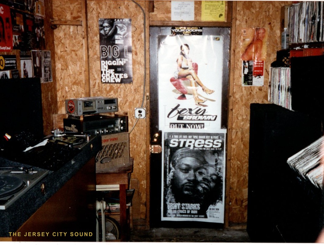 Basement studio with turntables, a cassette deck, records, and Big L, Foxy Brown, and Stress magazine posters
